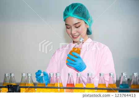 Worker Checking quality or checking stock of glass bottle in beverage factory 123764413