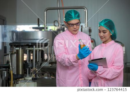Worker Checking quality or checking stock of glass bottle in beverage factory Worker Checking quality or checking stock of glass bottle in beverage factory 123764415