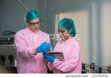Worker Checking quality or checking stock of glass bottle in beverage factory Worker Checking quality or checking stock of glass bottle in beverage factory 123764416