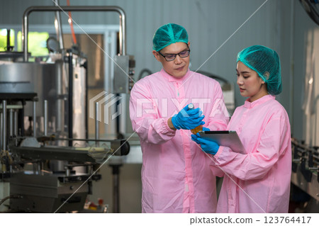 Worker Checking quality or checking stock of glass bottle in beverage factory Worker Checking quality or checking stock of glass bottle in beverage factory 123764417