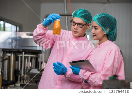 Worker Checking quality or checking stock of glass bottle in beverage factory Worker Checking quality or checking stock of glass bottle in beverage factory 123764418
