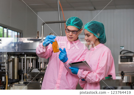 Worker Checking quality or checking stock of glass bottle in beverage factory Worker Checking quality or checking stock of glass bottle in beverage factory 123764419
