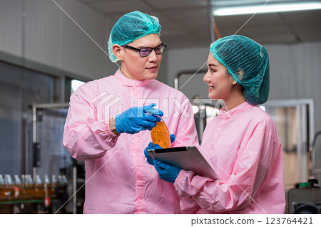 Worker Checking quality or checking stock of glass bottle in beverage factory Worker Checking quality or checking stock of glass bottle in beverage factory 123764421
