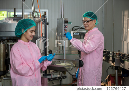 Worker Checking quality or checking stock of glass bottle in beverage factory 123764427