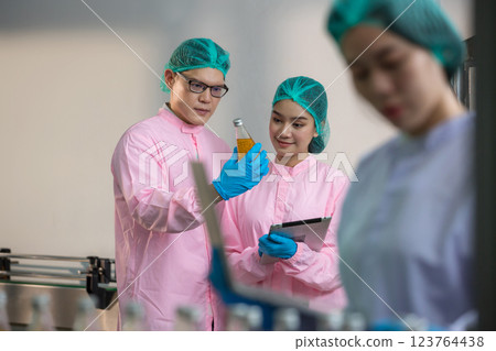 Worker Checking quality or checking stock of glass bottle in beverage factory 123764438
