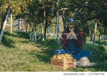 Farmer working in orange orchard. Farmer working in orange orchard. 123764748