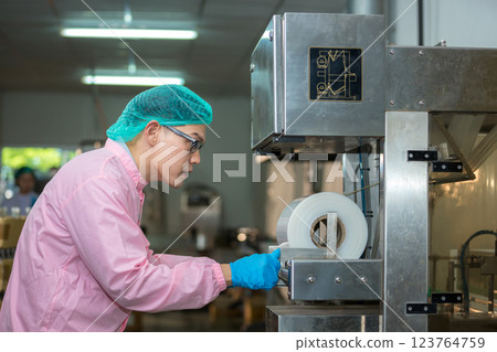 Worker Checking quality or checking stock of glass bottle in beverage factory Worker Checking quality or checking stock of glass bottle in beverage factory 123764759