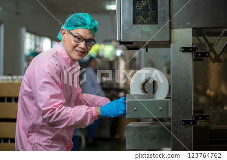 Worker Checking quality or checking stock of glass bottle in beverage factory Worker Checking quality or checking stock of glass bottle in beverage factory 123764762