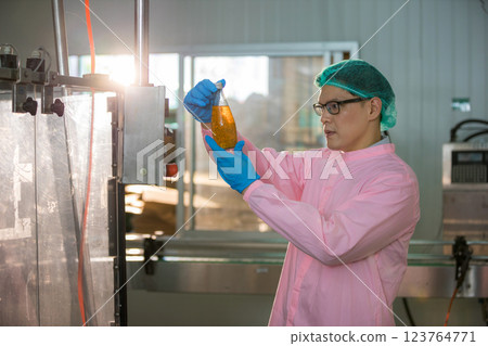 Worker Checking quality or checking stock of glass bottle in beverage factory Worker Checking quality or checking stock of glass bottle in beverage factory 123764771