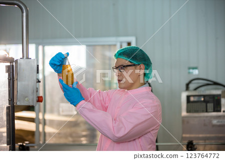 Worker Checking quality or checking stock of glass bottle in beverage factory Worker Checking quality or checking stock of glass bottle in beverage factory 123764772