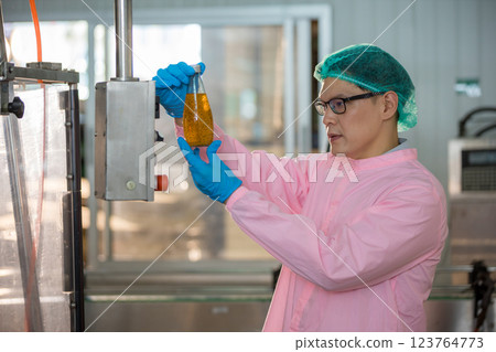 Worker Checking quality or checking stock of glass bottle in beverage factory 123764773
