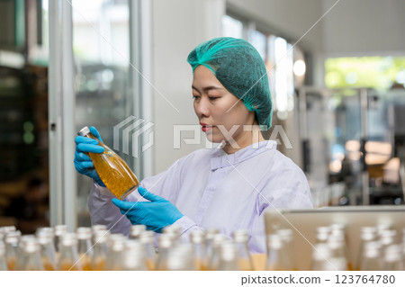 Worker Checking quality or checking stock of glass bottle in beverage factory Worker Checking quality or checking stock of glass bottle in beverage factory 123764780