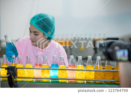 Worker Checking quality or checking stock of glass bottle in beverage factory. Worker Checking quality or checking stock of glass bottle in beverage factory. 123764799