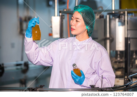 Worker Checking quality or checking stock of glass bottle in beverage factory. 123764807