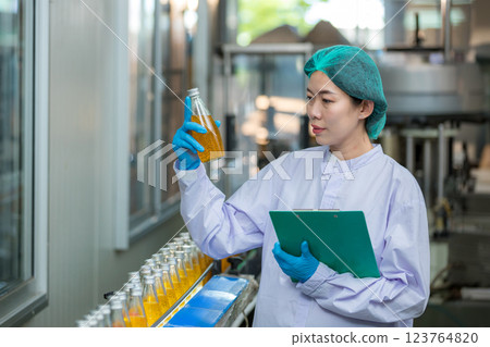 Worker Checking quality or checking stock of glass bottle in beverage factory. Worker Checking quality or checking stock of glass bottle in beverage factory. 123764820