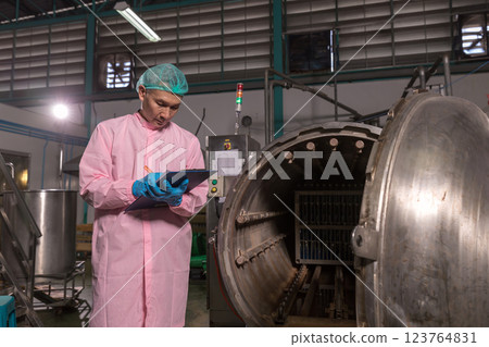 Worker Checking quality or checking stock of glass bottle in beverage factory.  Worker Checking quality or checking stock of glass bottle in beverage factory.  123764831