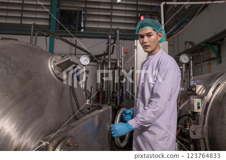 Worker Checking quality or checking stock of glass bottle in beverage factory.  123764833