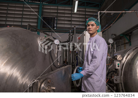 Worker Checking quality or checking stock of glass bottle in beverage factory.  123764834