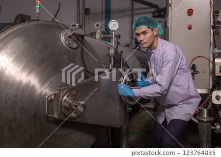 Worker Checking quality or checking stock of glass bottle in beverage factory.  123764835