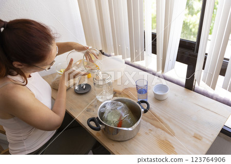 Woman pouring water into jar with fish in plastic bag, acclimating fish to new aquarium 123764906