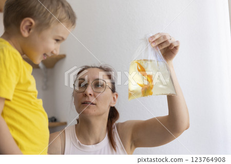 Mother showing goldfish in plastic bag to child 123764908