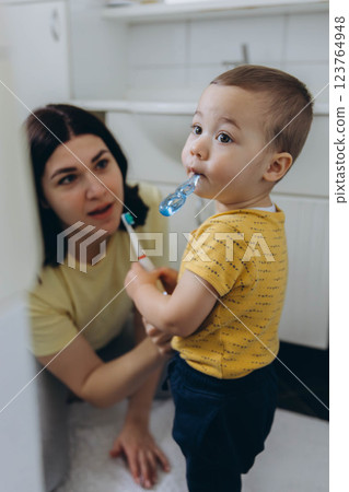 Dental care, mother brushing teeth with boy for wellness,Bathroom, oral health toothbrush Dental care, mother brushing teeth with boy for wellness,Bathroom, oral health toothbrush 123764948