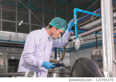 Worker Checking quality or checking stock of glass bottle in beverage factory. Worker Checking quality or checking stock of glass bottle in beverage factory. 123765278