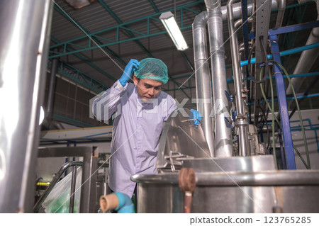 Worker Checking quality or checking stock of glass bottle in beverage factory. Worker Checking quality or checking stock of glass bottle in beverage factory. 123765285