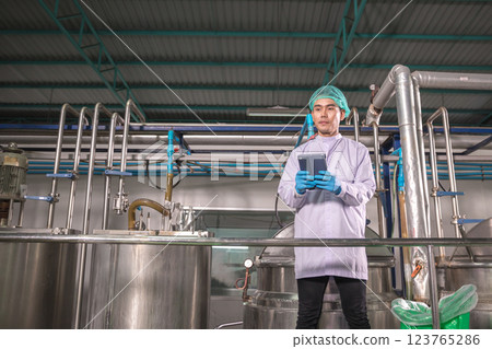 Worker Checking quality or checking stock of glass bottle in beverage factory. Worker Checking quality or checking stock of glass bottle in beverage factory. 123765286