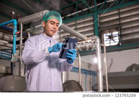 Worker Checking quality or checking stock of glass bottle in beverage factory. Worker Checking quality or checking stock of glass bottle in beverage factory. 123765289