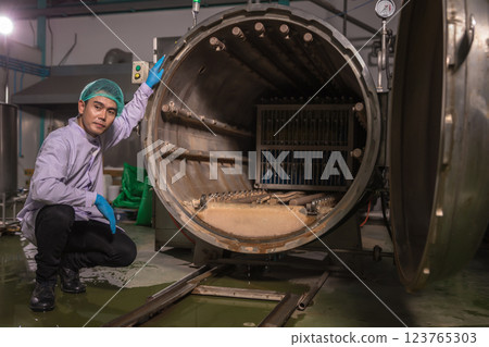 Worker Checking quality or checking stock of glass bottle in beverage factory. Worker Checking quality or checking stock of glass bottle in beverage factory. 123765303