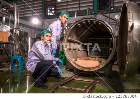 Worker Checking quality or checking stock of glass bottle in beverage factory. Worker Checking quality or checking stock of glass bottle in beverage factory. 123765304