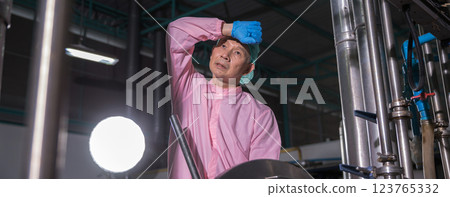 Worker Checking quality or checking stock of glass bottle in beverage factory. 123765332