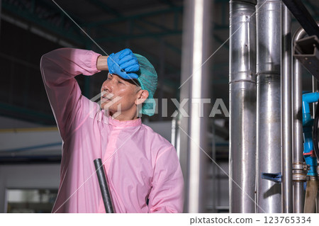 Worker Checking quality or checking stock of glass bottle in beverage factory. Worker Checking quality or checking stock of glass bottle in beverage factory. 123765334