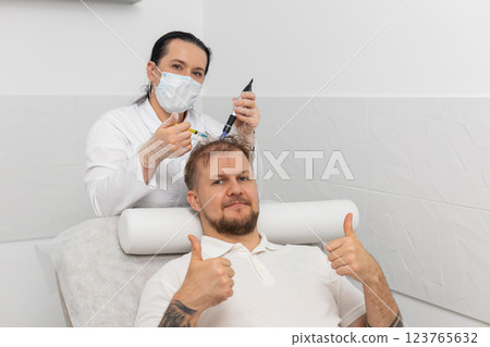 Trichologist doing man improve hair growth procedure, dermapen microneedling, vitamin injections Trichologist doing man improve hair growth procedure, dermapen microneedling, vitamin injections 123765632