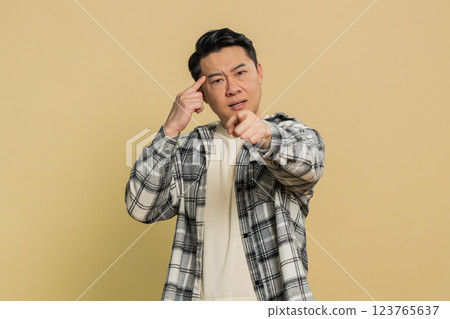Confused Asian man pointing at camera showing stupid asking for insane crazy bad plan, bullying 123765637