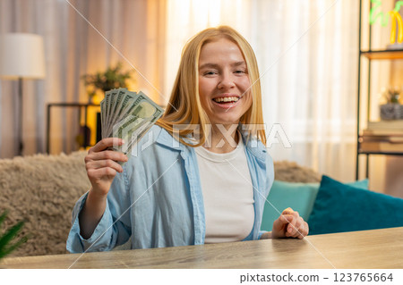 Young woman winning lottery at home table, money bundle, laughter, big joy, lucky moment, happy Young woman winning lottery at home table, money bundle, laughter, big joy, lucky moment, happy 123765664
