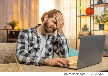 Young man working at home, laptop frustration, facepalm, critical error found, annoyed muttering Young man working at home, laptop frustration, facepalm, critical error found, annoyed muttering 123765666