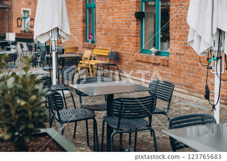 Outdoor cafe seating with tables and chairs Outdoor cafe seating with tables and chairs 123765683