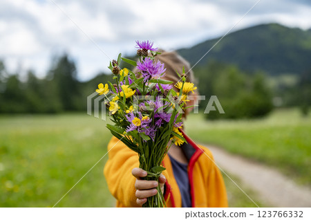 Child offering a bouquet of wildflowers Child offering a bouquet of wildflowers 123766332