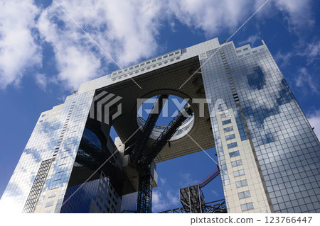 大阪梅田的一棟高樓。藍天和白雲倒映在建築的玻璃和外牆上。 123766447