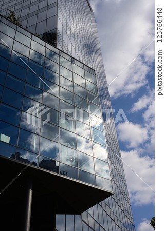 大阪梅田的一棟高樓。藍天和白雲倒映在建築的玻璃和外牆上。 大阪梅田的一棟高樓。藍天和白雲倒映在建築的玻璃和外牆上。 123766448