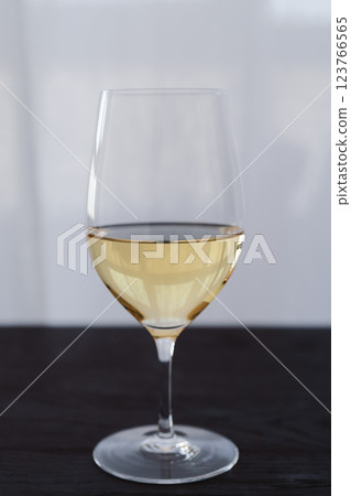 White wine in a wineglass on black oak table with copy space 123766565