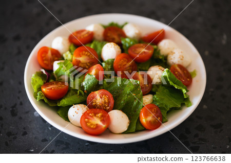 Salad with mozzarella balls tomatoes and mix salad 123766638