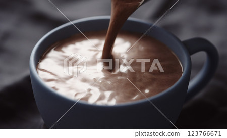 pour hot chocolate into blue cup closeup 123766671