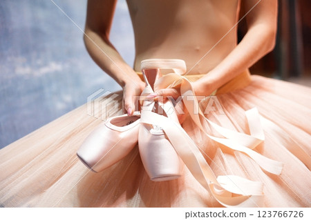 Ballerina Holding Pointe Shoes in Elegant Tutu  123766726