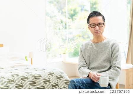 Middle-aged man drinking coffee in bedroom 123767105