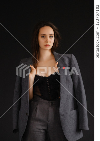 Confident Woman in a Gray Suit and Corset 123767182