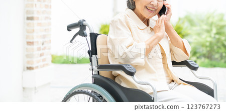 一位坐在輪椅上的老年婦女在用智慧型手機聊天 123767273