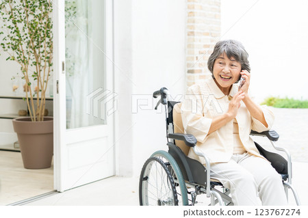 一位坐在輪椅上的老年婦女在用智慧型手機聊天 123767274